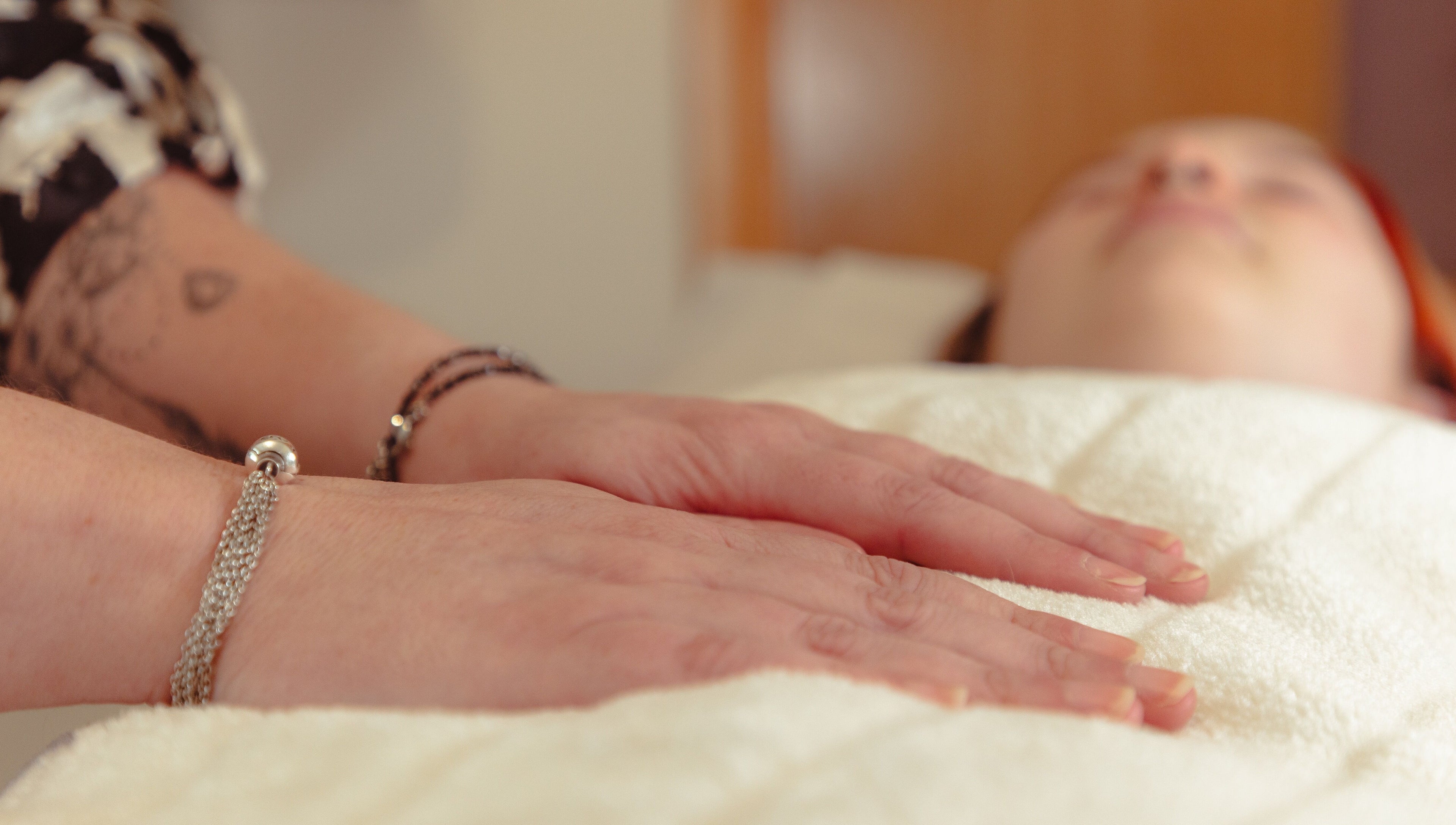 Relaxing Reiki session at Hummingbird Haven, Bray, County Wicklow, IE. Hands resting gently on a towel.