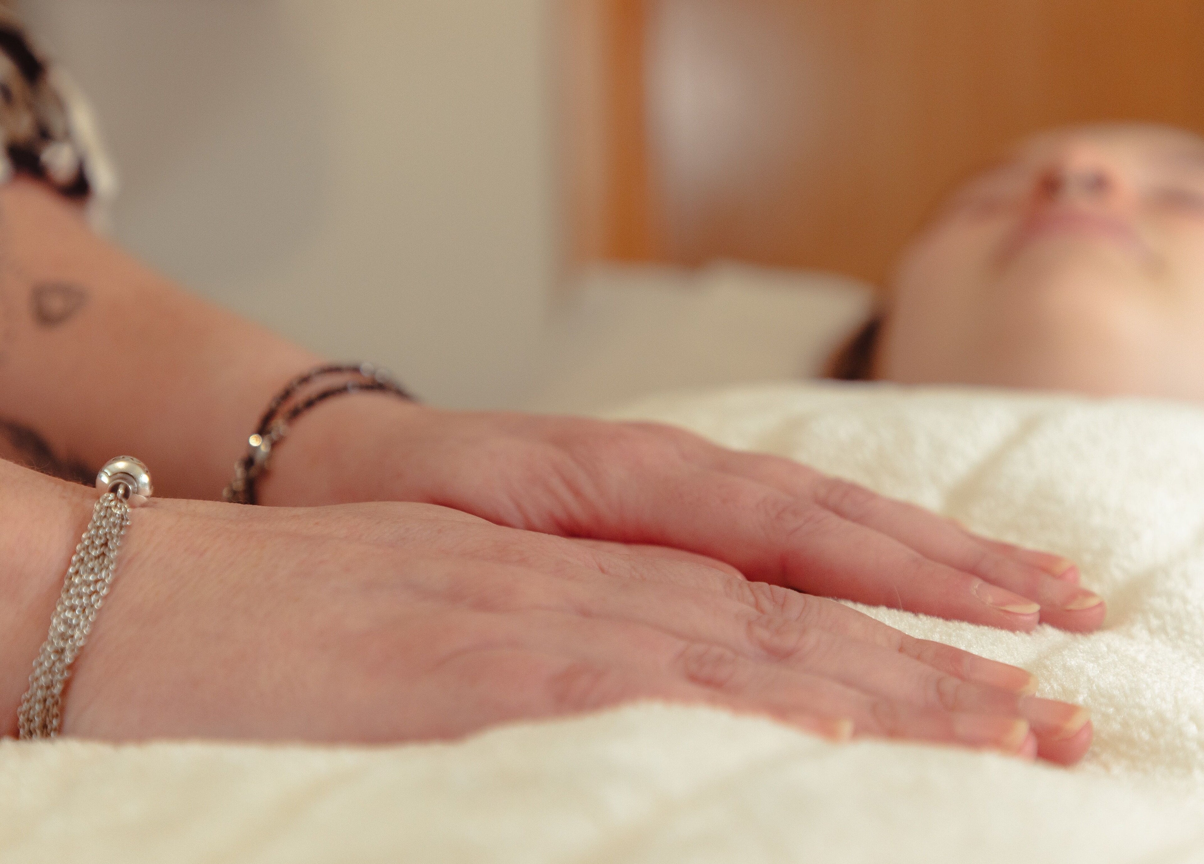 Relaxing Reiki session at Hummingbird Haven, Bray, County Wicklow, IE. Hands resting gently on a towel.