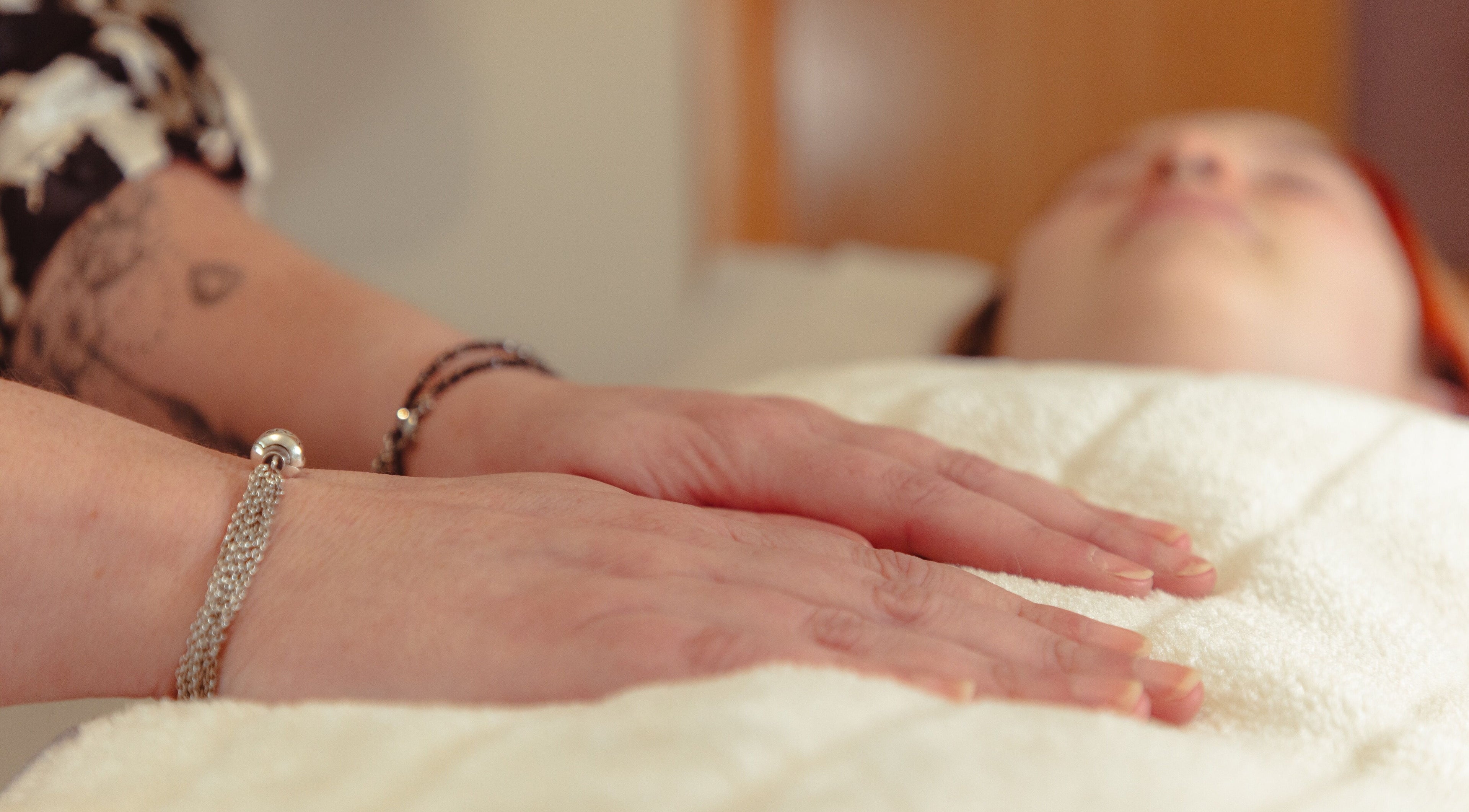 Relaxing Reiki session at Hummingbird Haven, Bray, County Wicklow, IE. Hands resting gently on a towel.