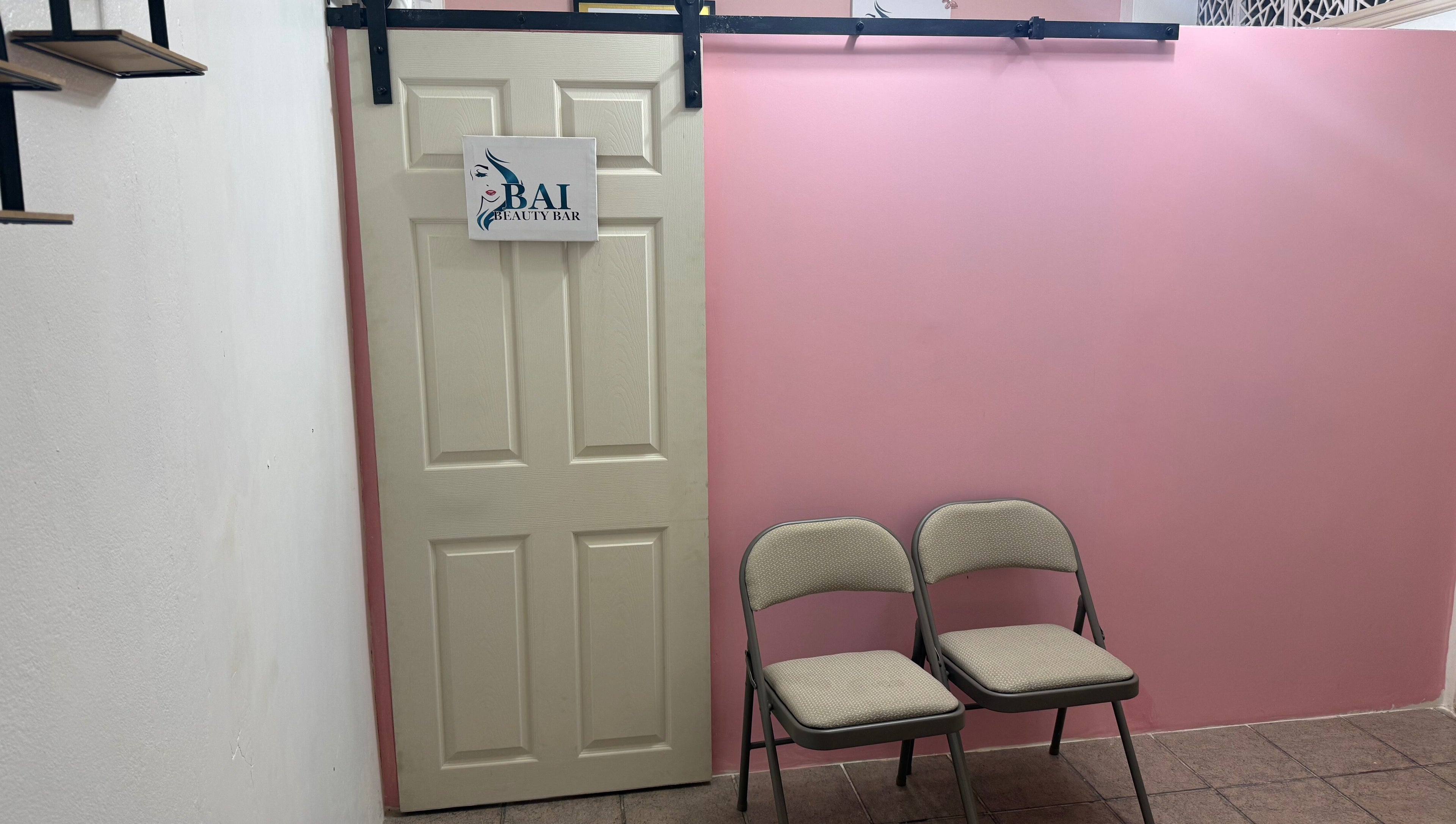 Entrance to Bai Beauty Bar in Kingston, St. Andrew Parish, JM with pink walls and waiting chairs.