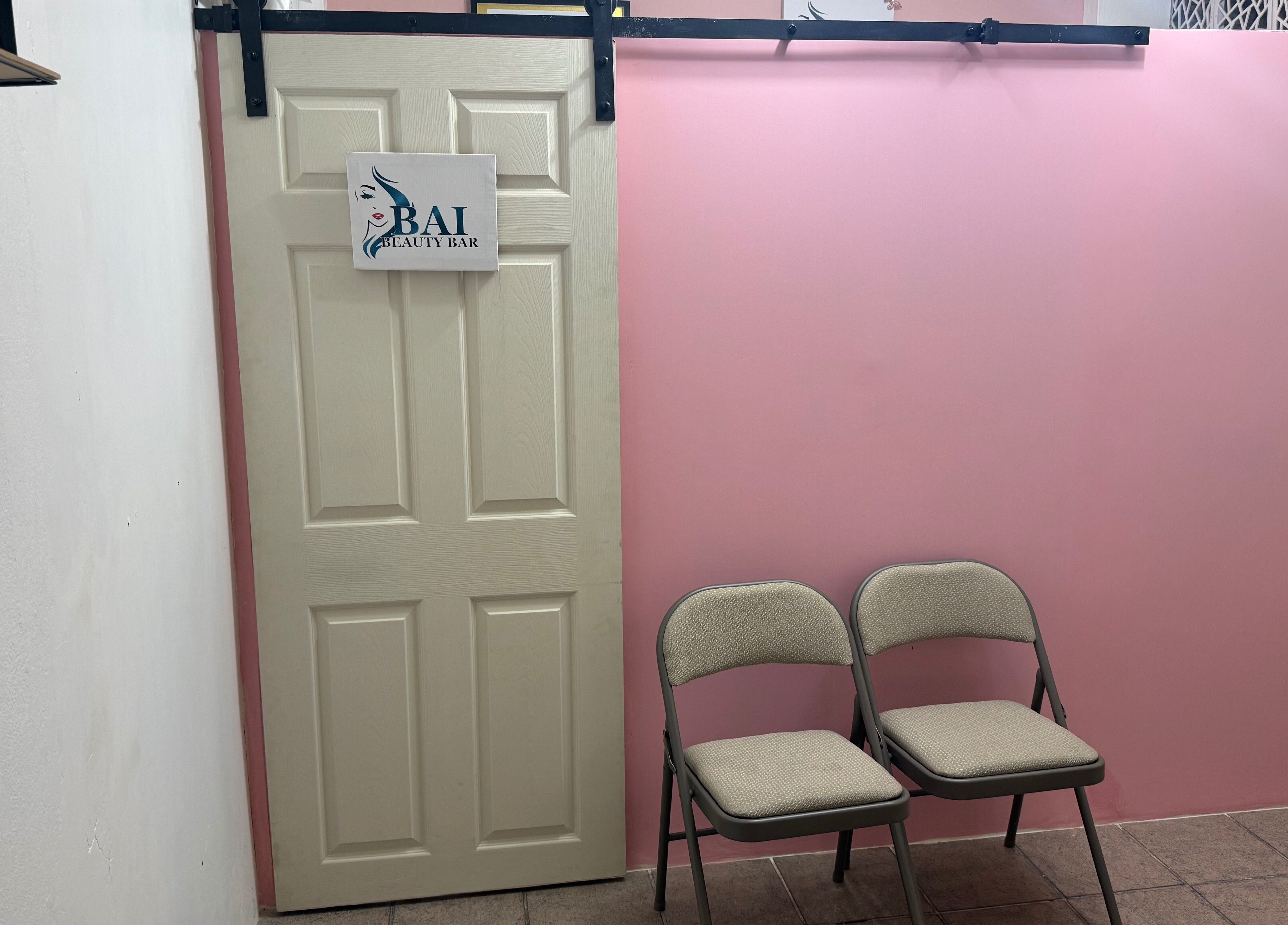 Entrance to Bai Beauty Bar in Kingston, St. Andrew Parish, JM with pink walls and waiting chairs.