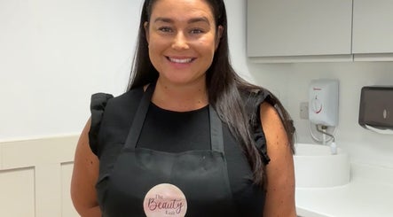 A friendly stylist at The Beauty Loft, Kirkby In Ashfield, England, GB, showcasing her apron in a bright salon.
