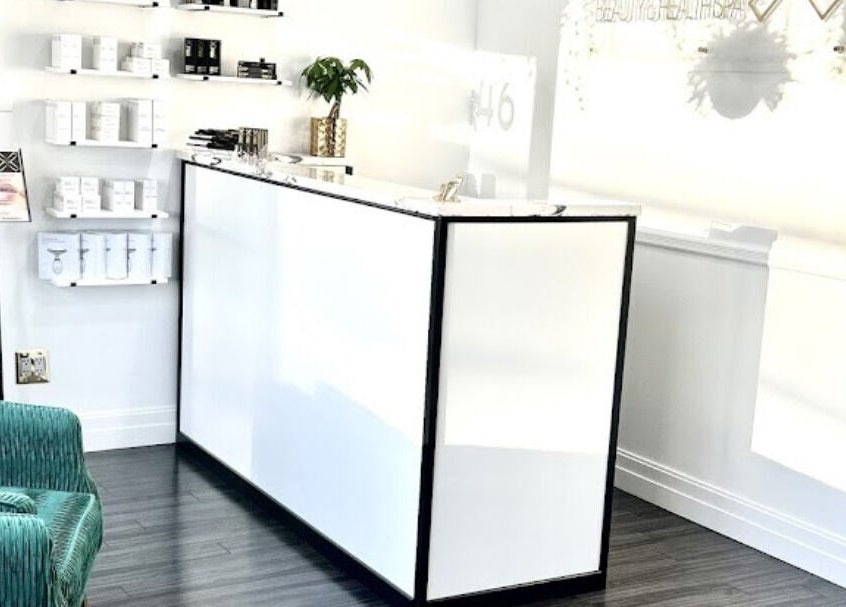 Reception at Rebelle X Health & Beauty Spa in North Massapequa, New York, US with sleek white decor.