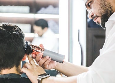 Barber trimming hair at The British Barbers, Singapore, Singapore, SG.