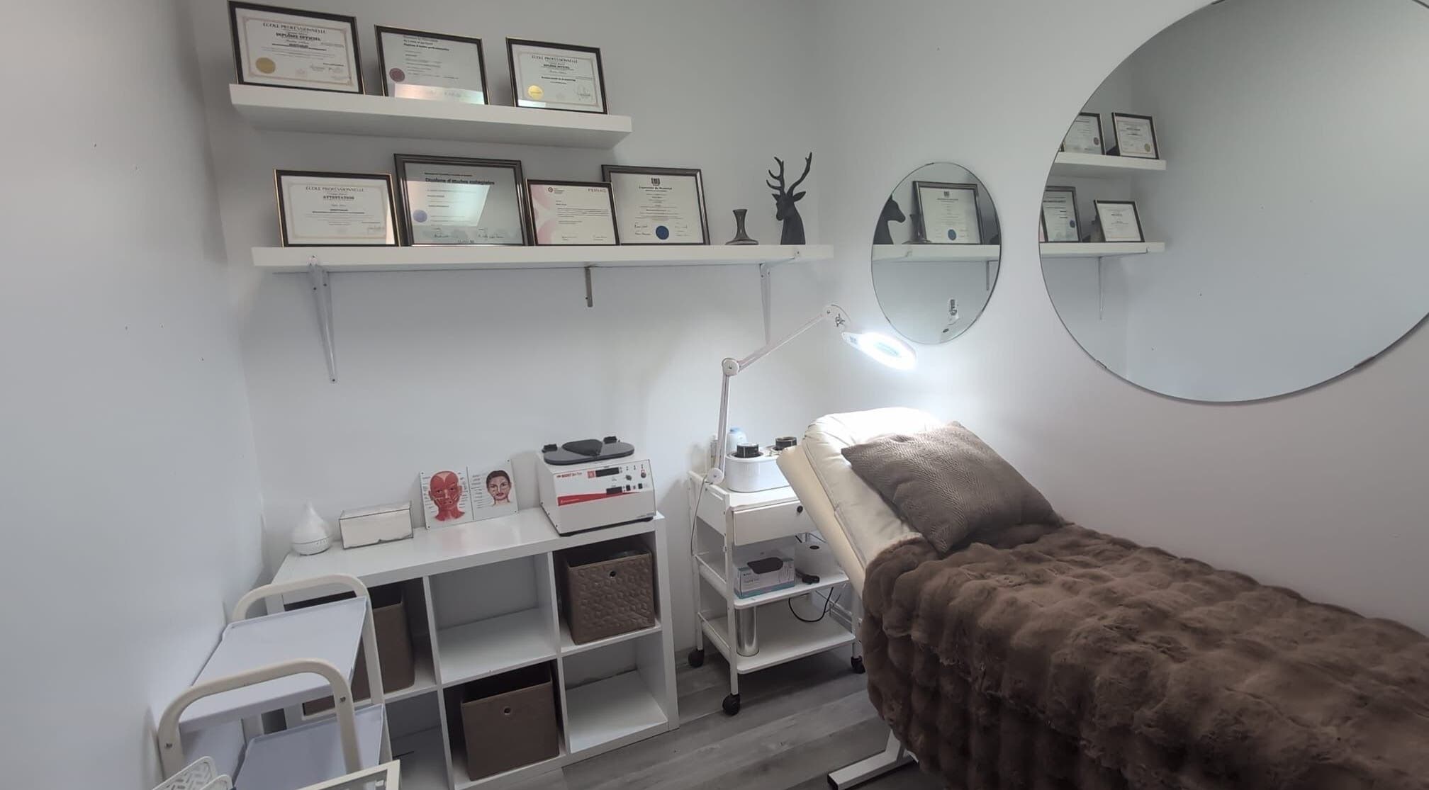 Salle de soins élégante de Fancy care esthétique à Terrebonne, Québec, CA, avec diplômes affichés.