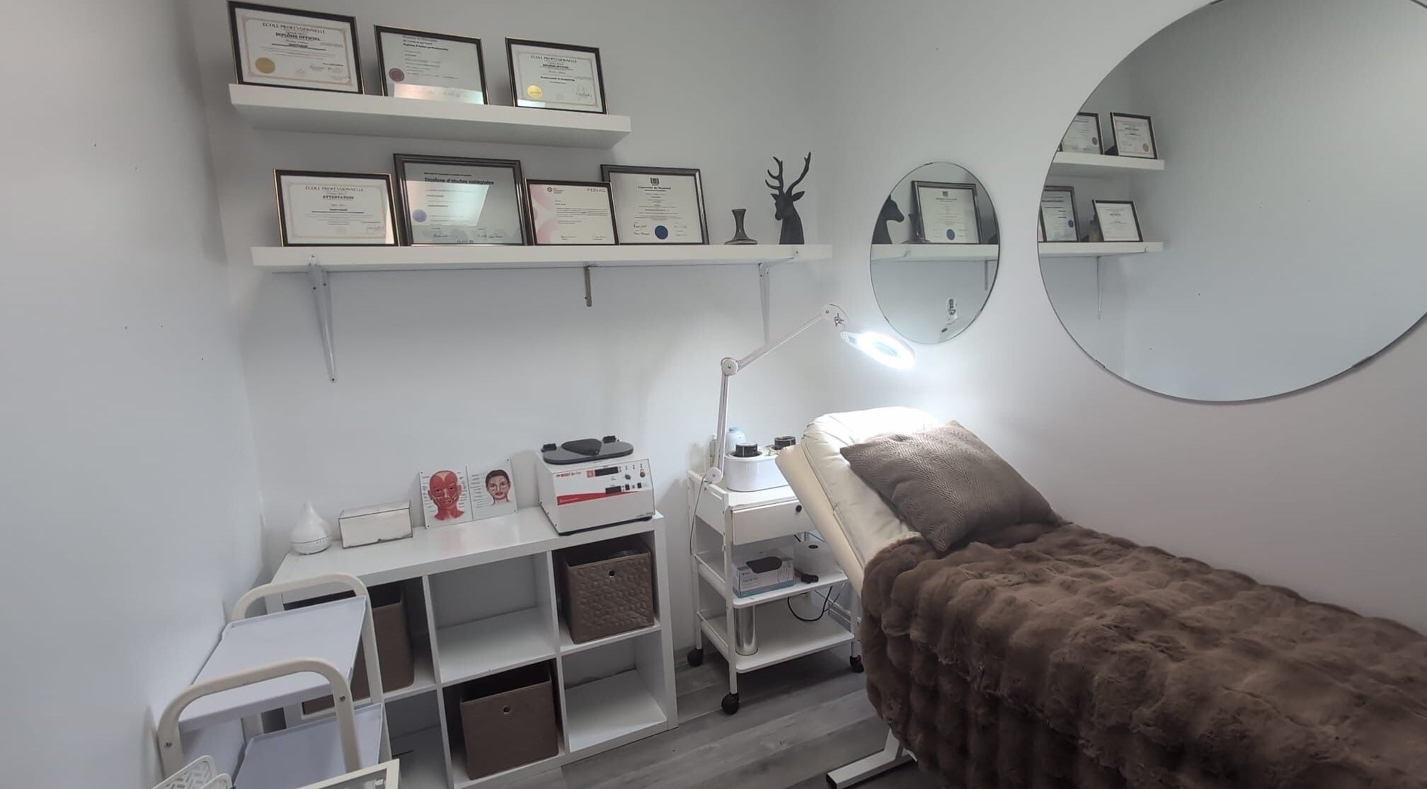 Salle de soins élégante de Fancy care esthétique à Terrebonne, Québec, CA, avec diplômes affichés.