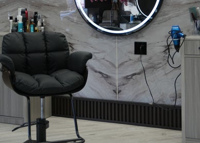 Sleek styling chair and mirror at Revive Hair Salon in Los Angeles, California, US, with tools neatly organized.