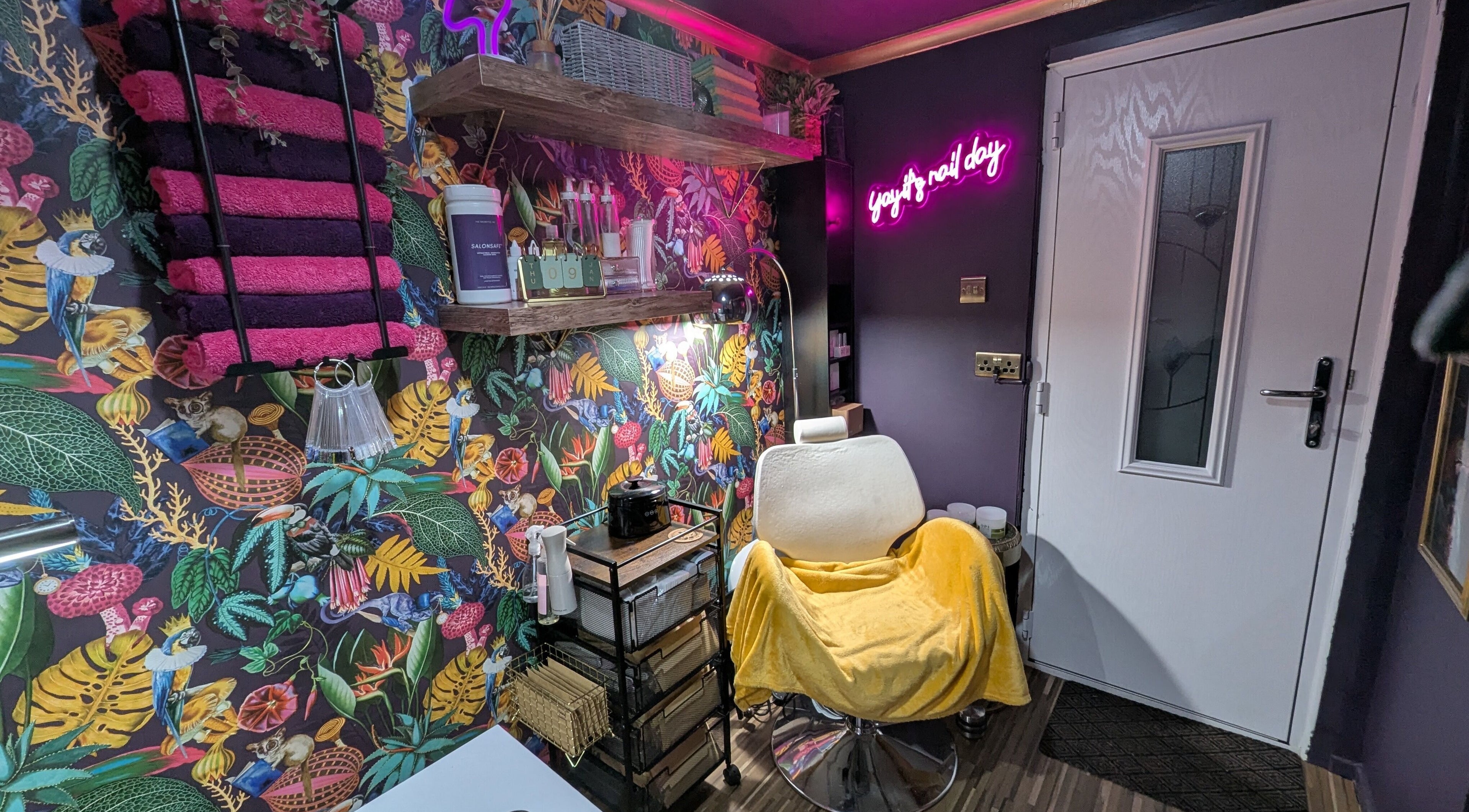 Colorful beauty space at The Nailbox Netherton, Dudley, England, GB with botanical wallpaper and salon chair.