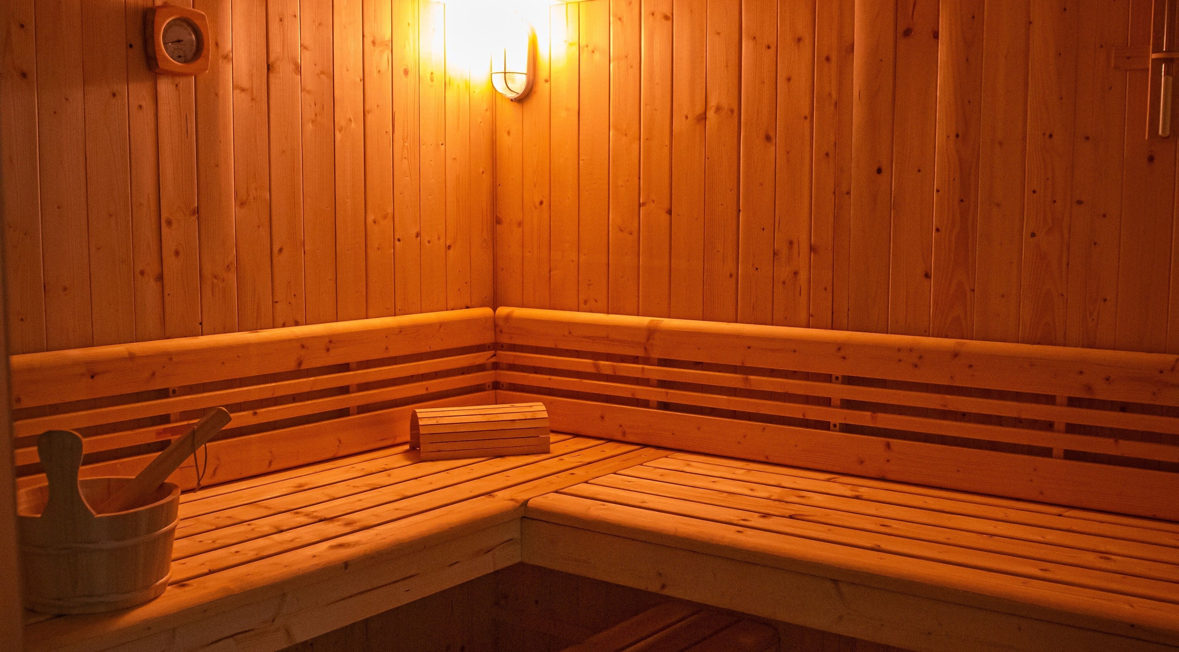 Interno della sauna a Artemide Suite & Spa, Campania, Campania, IT, con luci calde e legno naturale.