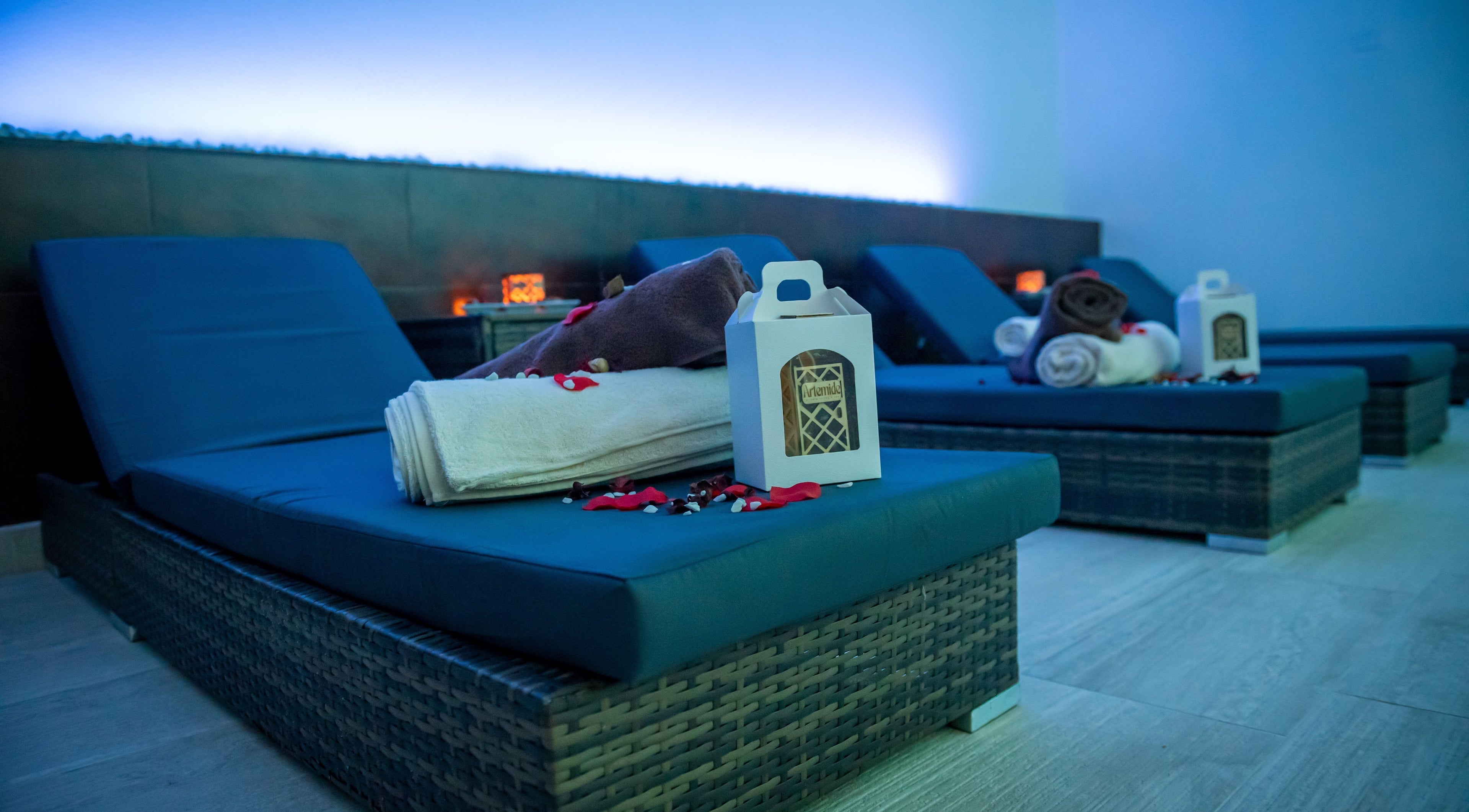 Lettini con asciugamani ad Artemide Suite & Spa, Campania, Campania, IT, illuminazione soffusa per relax completo.