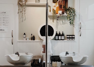 Chic salon interior at Cora and Co, Teignmouth, England, GB with modern washbasins and quality hair products.