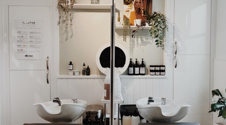 Chic salon interior at Cora and Co, Teignmouth, England, GB with modern washbasins and quality hair products.