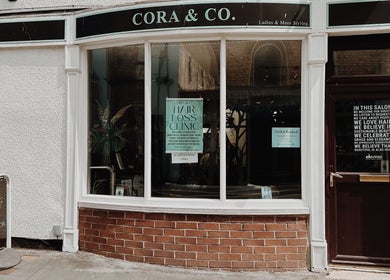 Entrance of Cora and Co beauty salon, Teignmouth, England, showcasing stylish exterior and signage.