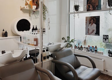 Interior of Cora and Co, Teignmouth, England, showcasing salon chairs and beauty products.