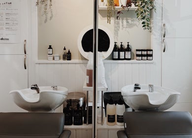 Modern hair wash station at Cora and Co, Teignmouth, England, GB with stylish sinks and products.