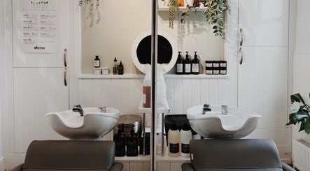 Modern hair wash station at Cora and Co, Teignmouth, England, GB with stylish sinks and products.