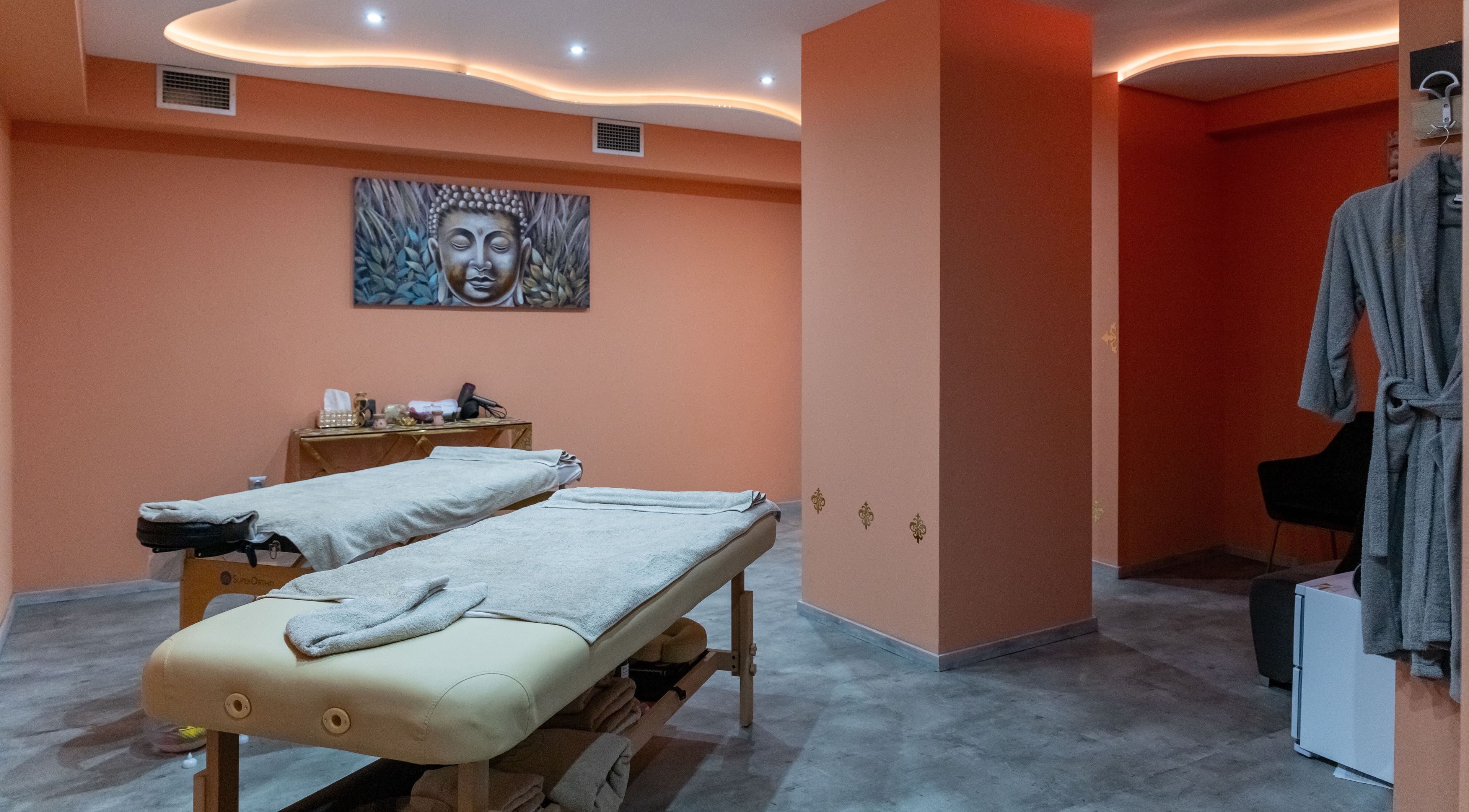 Δωμάτιο μασάζ στο Absolute Massage Ana Spa, Θεσσαλονίκη, GR με απαλή διακόσμηση και πίνακα Βούδα.