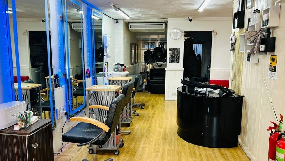 Modern salon interior at Hair & BeautyX in Gravesend, England, GB, featuring sleek chairs and mirrors.