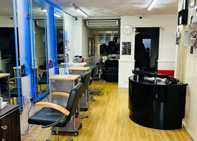 Modern salon interior at Hair & BeautyX in Gravesend, England, GB, featuring sleek chairs and mirrors.