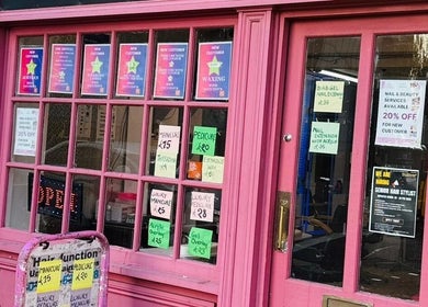 Charming pink storefront of Hair & BeautyX in Gravesend, England, GB featuring vibrant service offers.