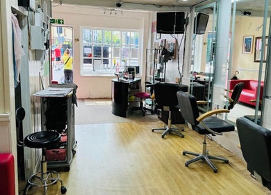 Modern salon interior at Hair & BeautyX, Gravesend, England, GB, with chic chairs and a vibrant atmosphere.