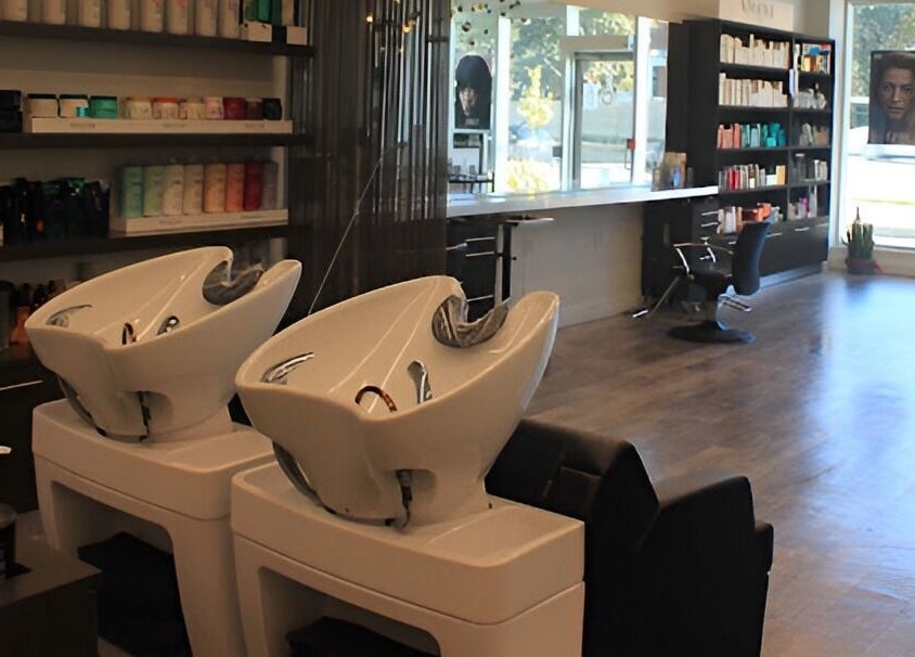 Sleek interior of DBK Salon Bayview, Toronto, Ontario, CA with hair wash stations and product shelves.