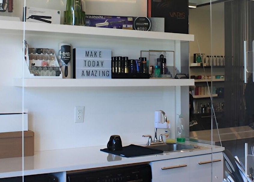 Sleek interior of DBK Salon Bayview, Toronto, Ontario, CA showcasing beauty products on white shelves.