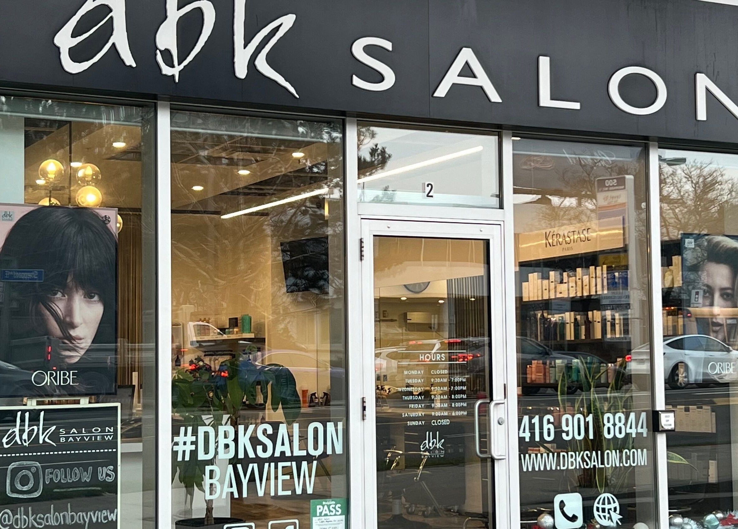Front entrance of DBK Salon Bayview in Toronto, Ontario, CA, showcasing modern glass facade and logo.