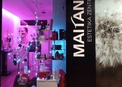 Fachada iluminada de MAITANE estetica en Azpeitia, Gipuzkoa, ES, llena de productos de belleza.