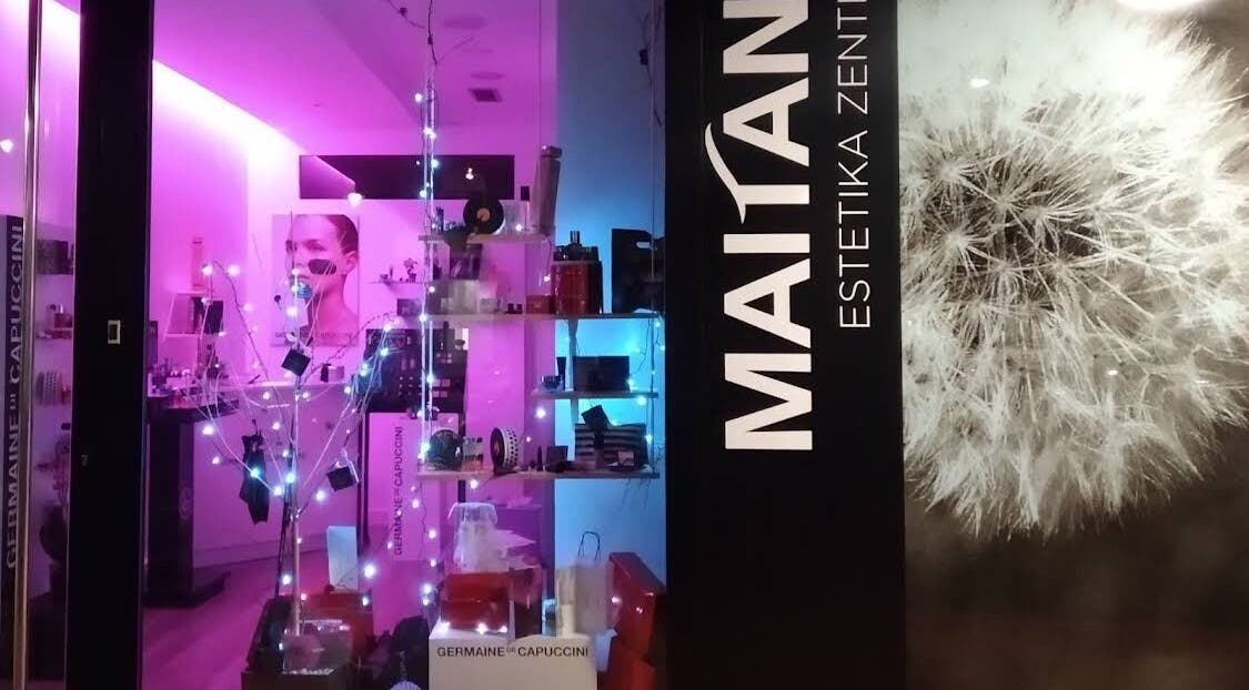 Fachada iluminada de MAITANE estetica en Azpeitia, Gipuzkoa, ES, llena de productos de belleza.