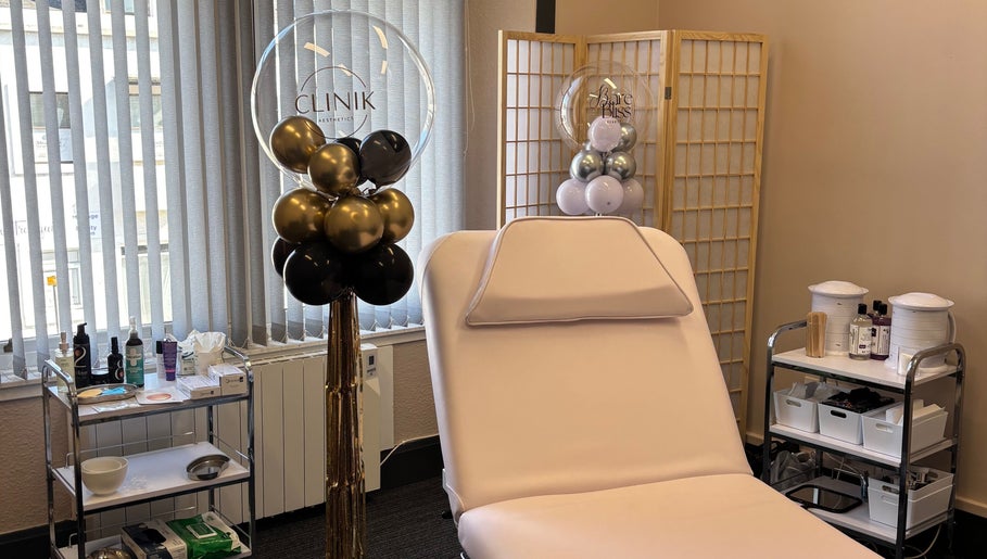 CliniK Aesthetics treatment room with plush bed and decor in Irvine, Scotland, GB.