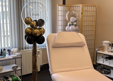 CliniK Aesthetics treatment room with plush bed and decor in Irvine, Scotland, GB.
