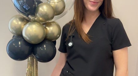 Staff member at CliniK Aesthetics, Irvine, Scotland, GB with decorative balloons, symbolizing a welcoming atmosphere.