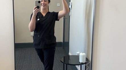 Staff member at CliniK Aesthetics in Irvine, Scotland, GB captures a mirror selfie in a treatment room.