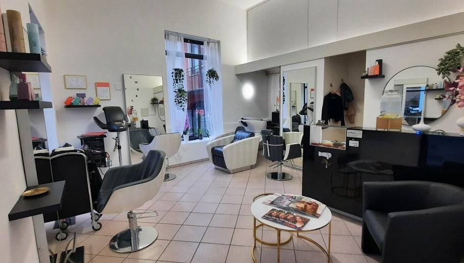 Interno moderno di Stefy Hair a Locarno, Ticino, CH, con salotto elegante e attrezzature professionali.