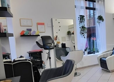 Interno elegante di Stefy Hair a Locarno, Ticino, CH con poltrone e specchi moderni.