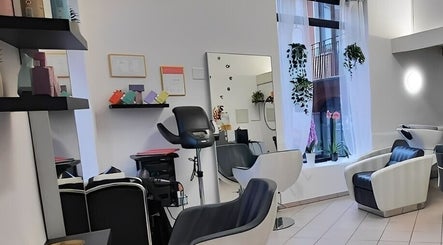 Interno elegante di Stefy Hair a Locarno, Ticino, CH con poltrone e specchi moderni.