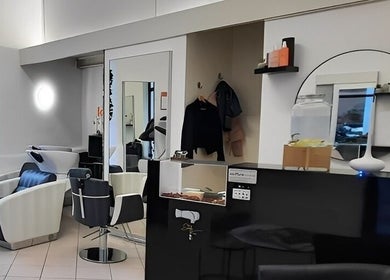 Interno elegante del salone Stefy Hair a Locarno, Ticino, CH, con sedie lussuose e specchi stylish.