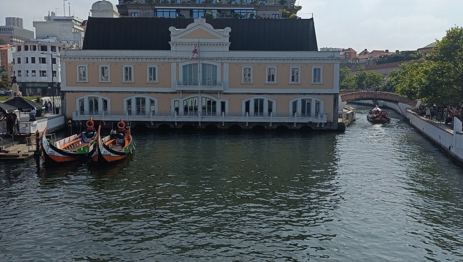 Barcos na frente de um edifício clássico em Aveiro, perto do JFG Clinic, Guimarães, Braga, PT.