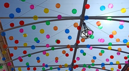Decoração colorida no teto da JFG Clinic, Guimarães, Braga, PT, com bolas suspensas vibrantes.