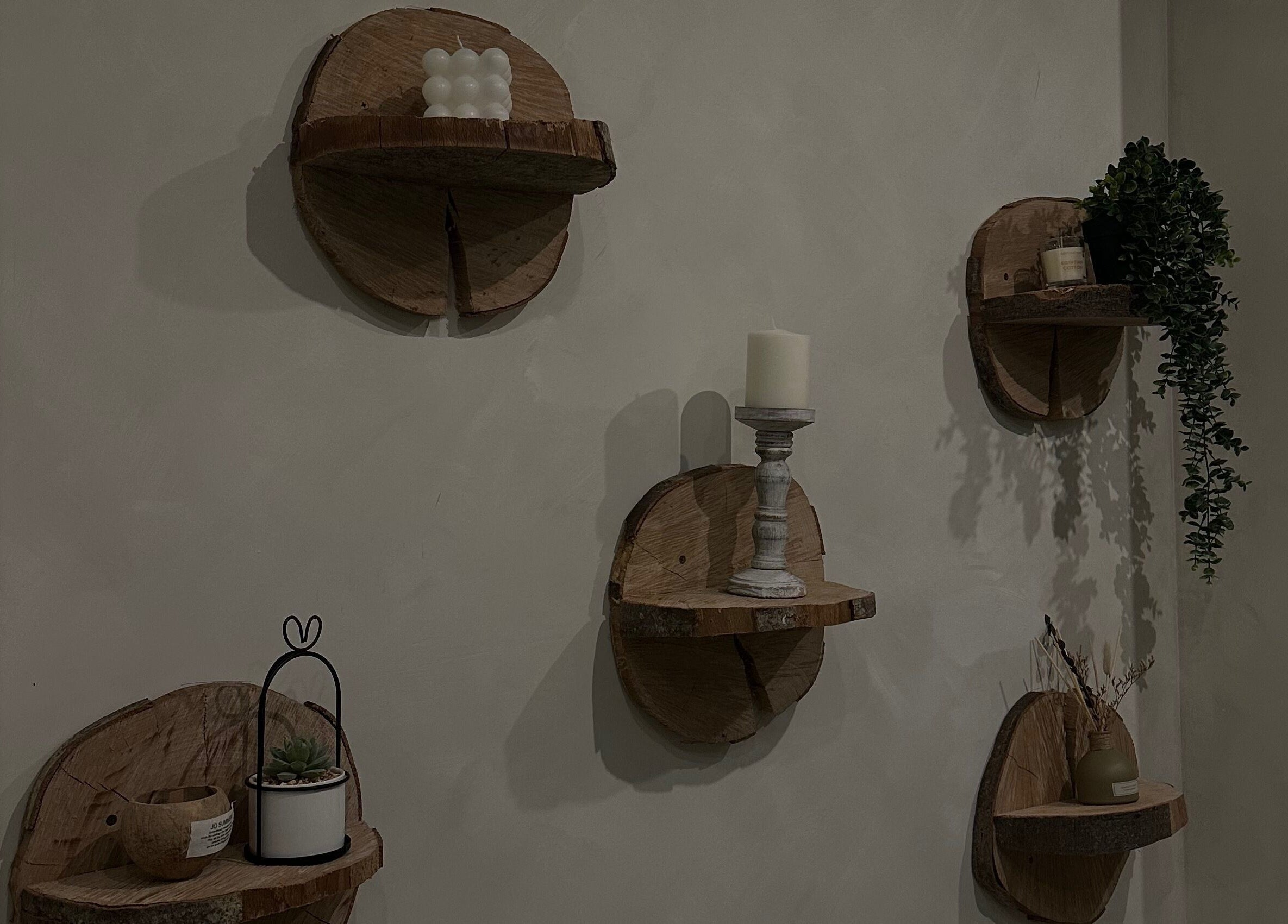 Decorative wooden wall shelves at Coconut & Co, Penrith, England, GB, showcasing candles and plants.