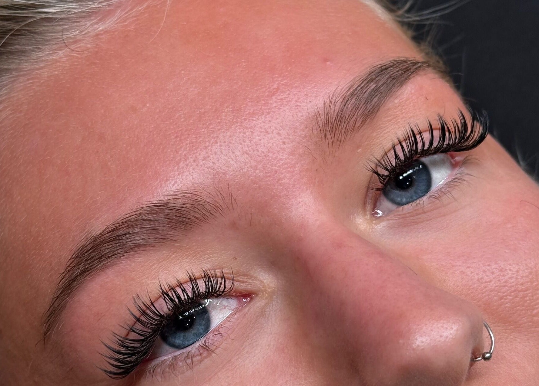 Close-up of styled eyelashes at Coconut & Co in Penrith, England, GB. Long lashes add elegance to blue eyes.