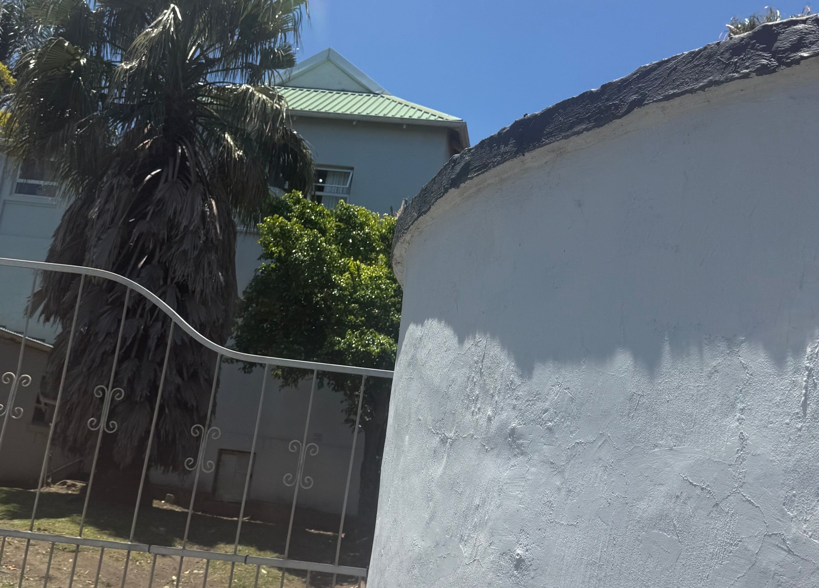 Exterior of AM BEAUTY, a serene retreat with lush palm trees in East London, Eastern Cape, ZA.