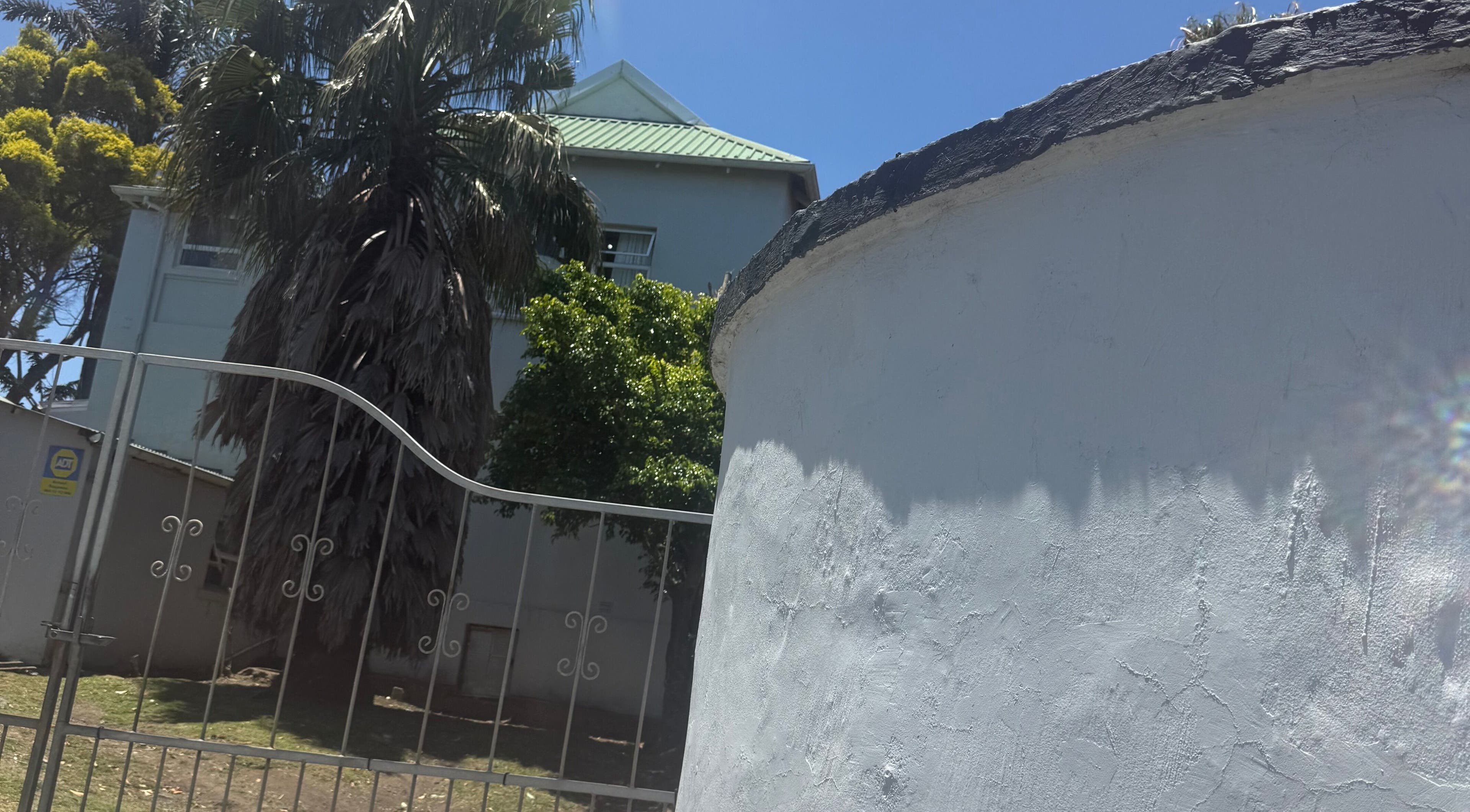 Exterior of AM BEAUTY, a serene retreat with lush palm trees in East London, Eastern Cape, ZA.