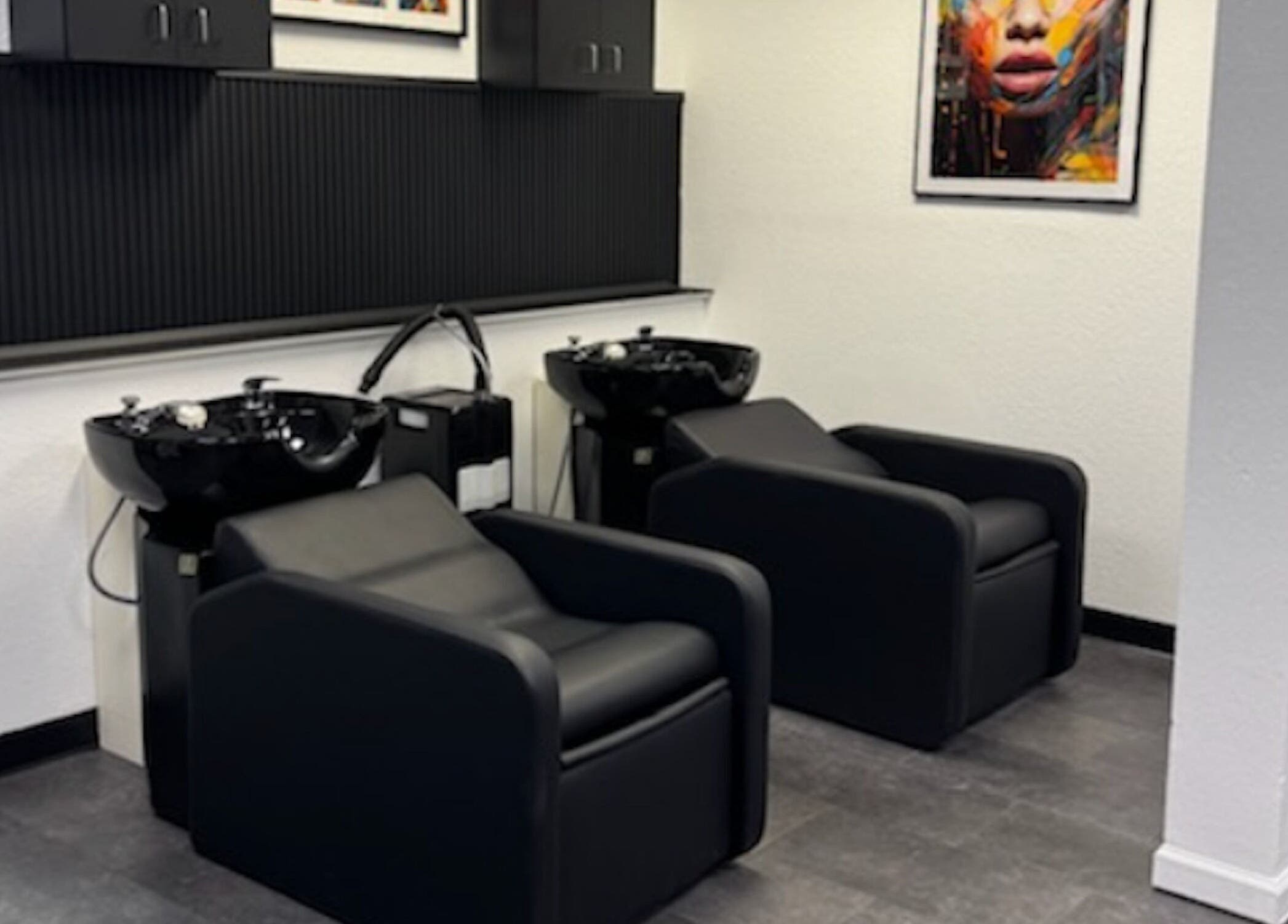 Modern hair wash stations at Fluent Strands, San Antonio, Texas, US, featuring sleek black chairs and decor.