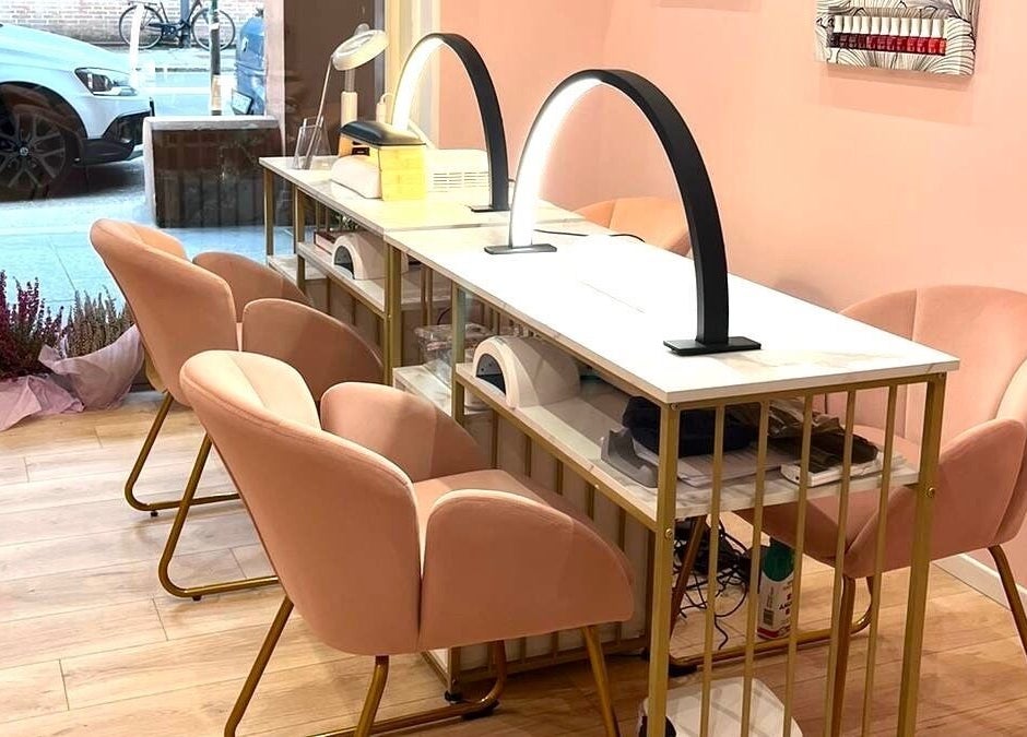 Elegant nail station at Nail It, Bologna, Emilia-romagna, IT, with soft pink chairs and modern lighting.
