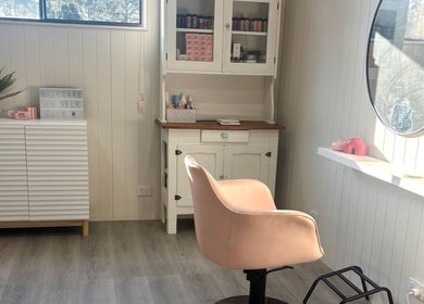 Chic salon interior with pink chair at Pink Honey Hair Studio, Lake Macdonald, Queensland, AU.
