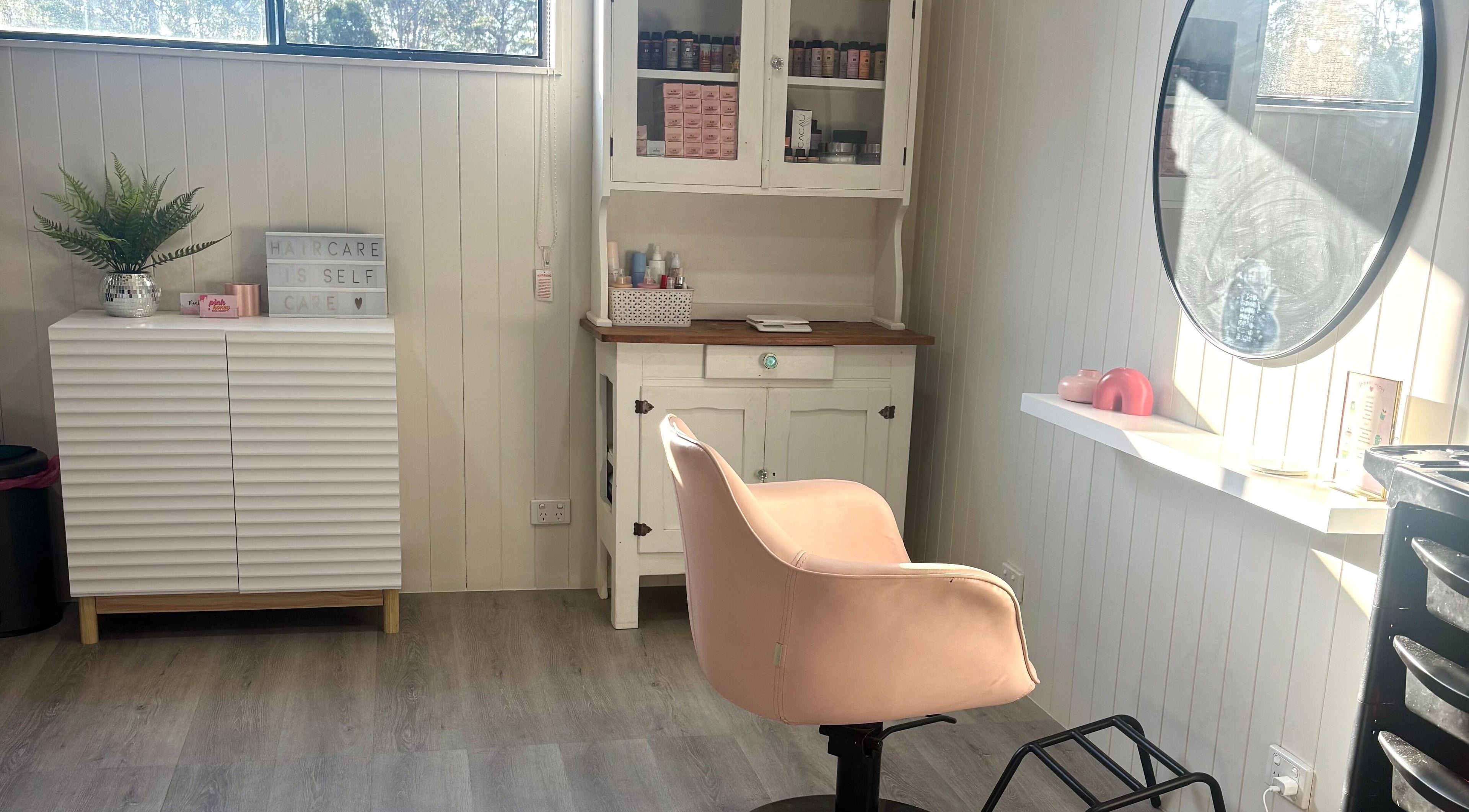 Chic salon interior with pink chair at Pink Honey Hair Studio, Lake Macdonald, Queensland, AU.