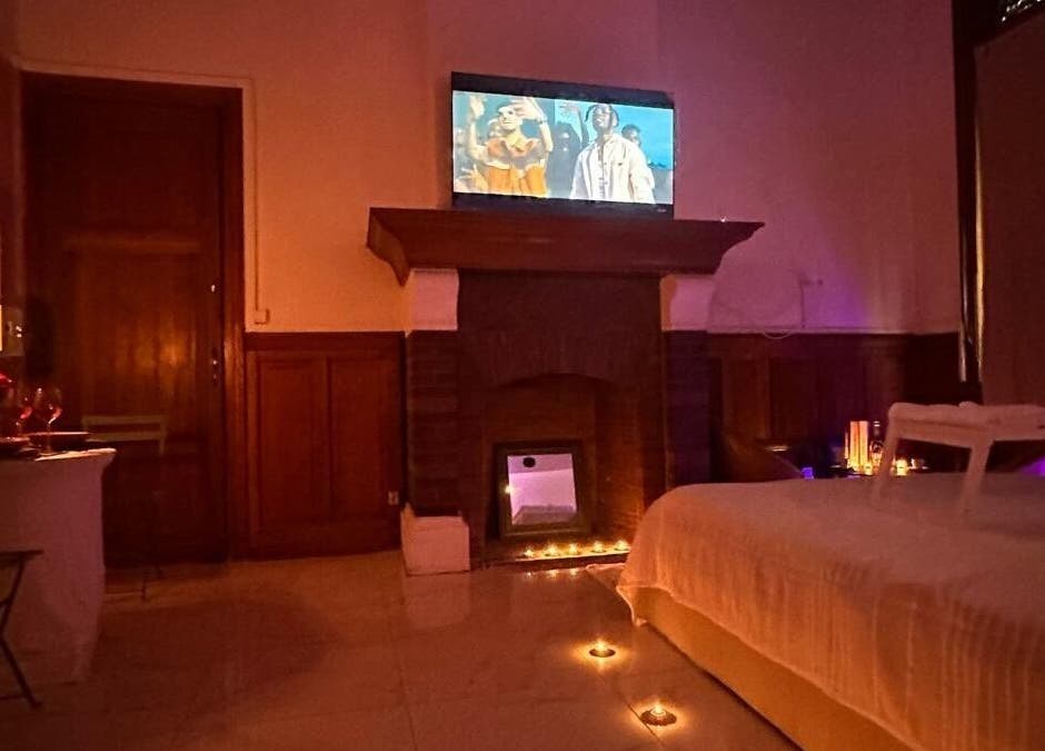 Salon cosy avec cheminée et bougies à Room 47, Tourcoing, Hauts-de-France, FR.