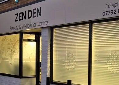 Exterior of Zen Den Beauty and Wellbeing Centre, Humberston, GB, with illuminated windows and signage.
